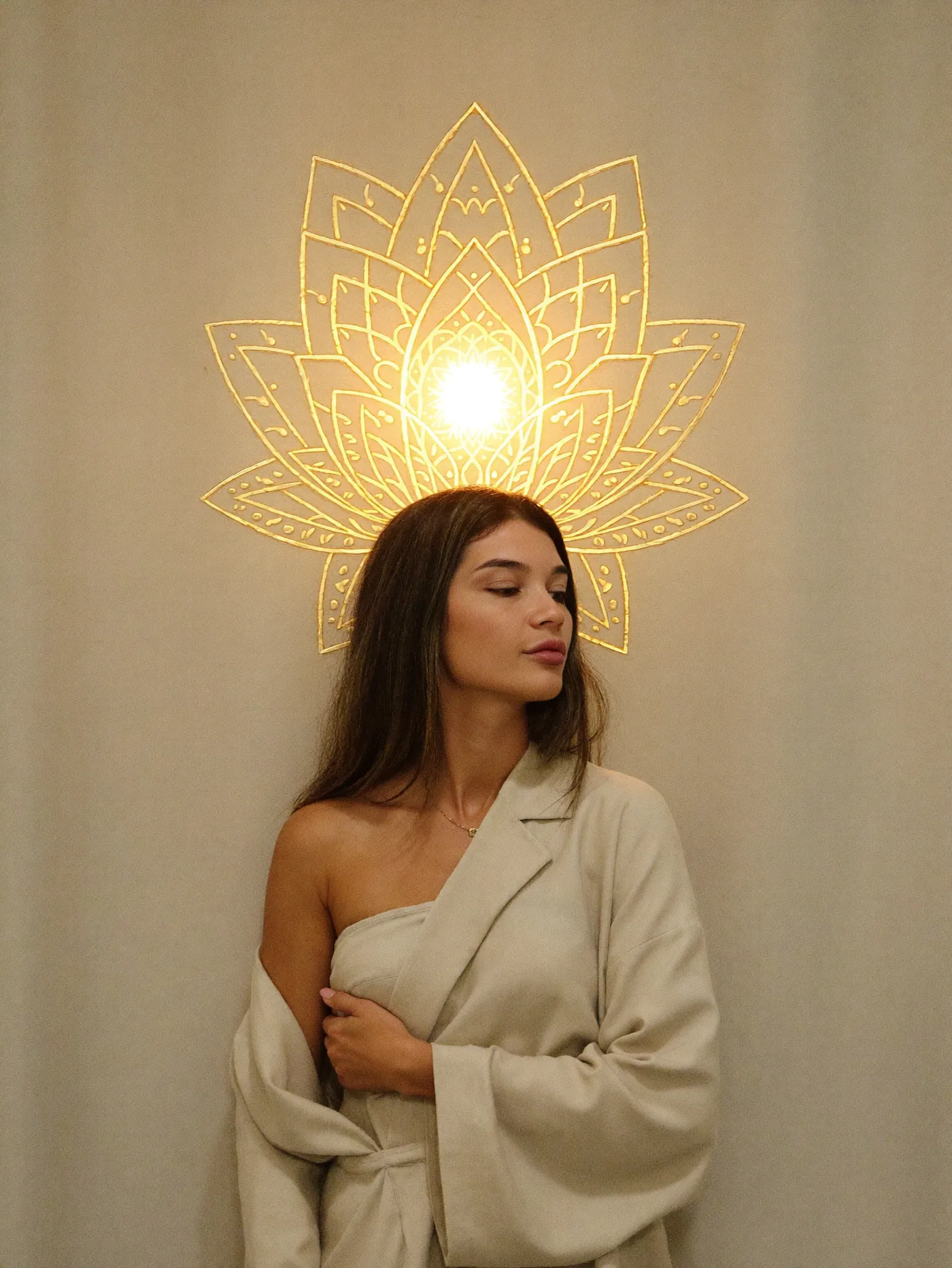 Vitoria Purcini de olhos fechados diante de uma lótus dourada de luz